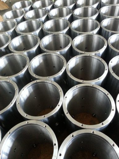 Reihen von silbernen Metallzylindern in einer Werkstatt.